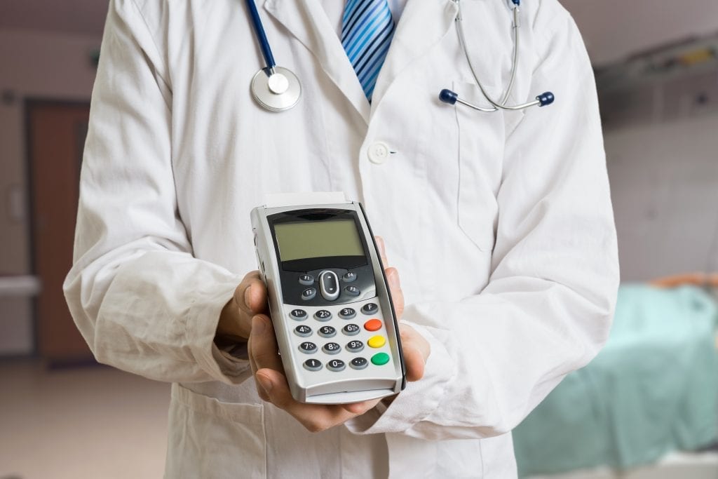 medical professional holding HICAPS machine for payment