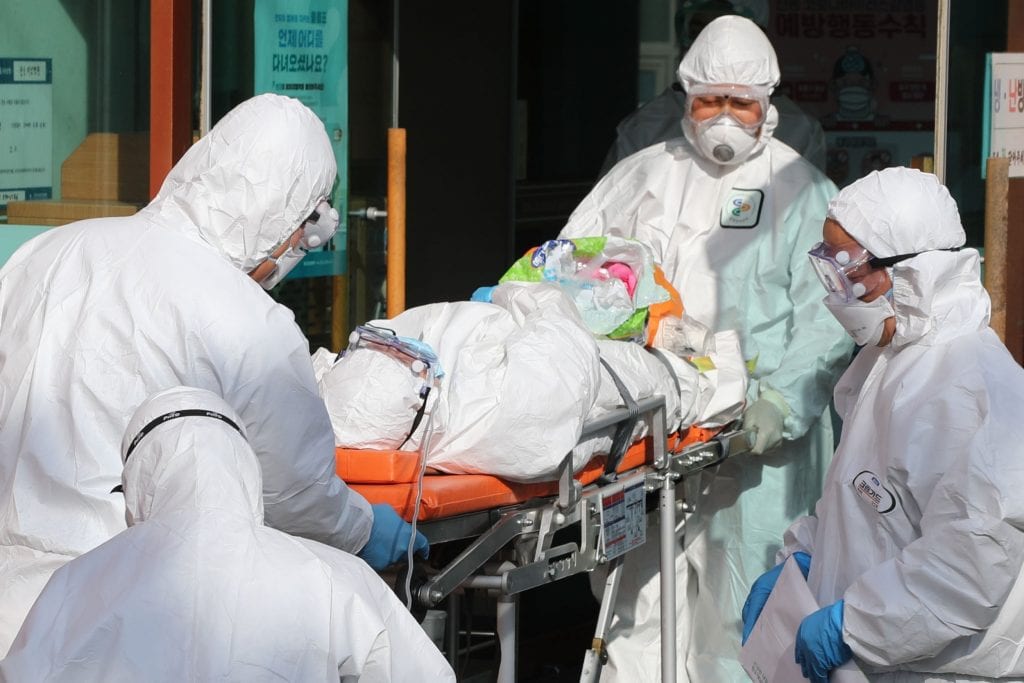 quarantine team wheeling a patient into the isolation ward