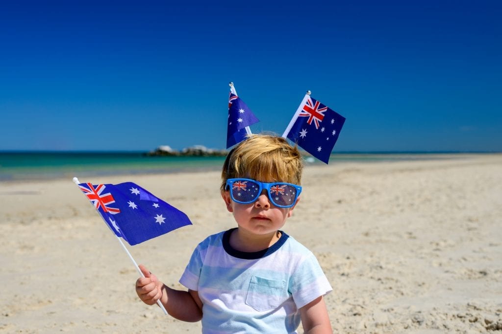 child on the beach waving wand wearing the Australian flag