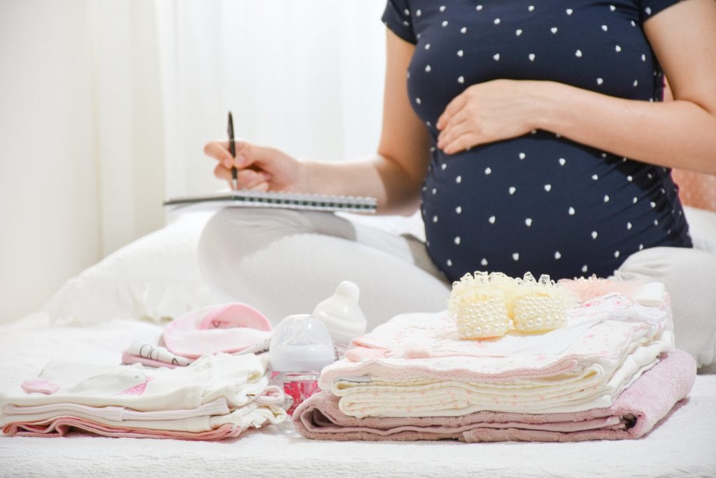 pregnant woman writing a checklist