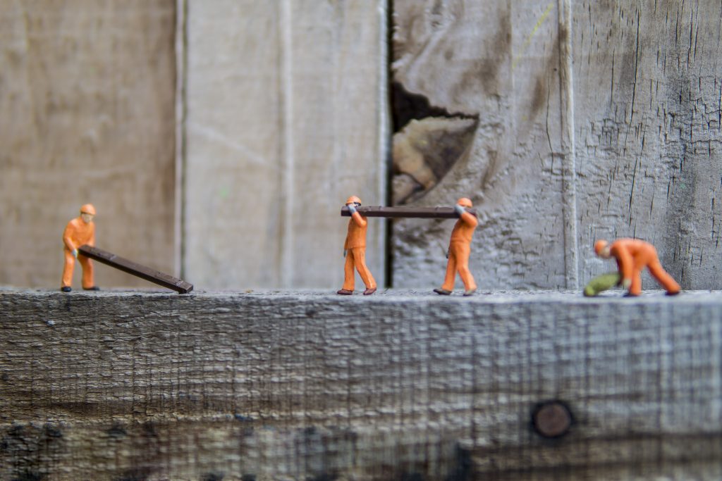 trade workers manually handling timber